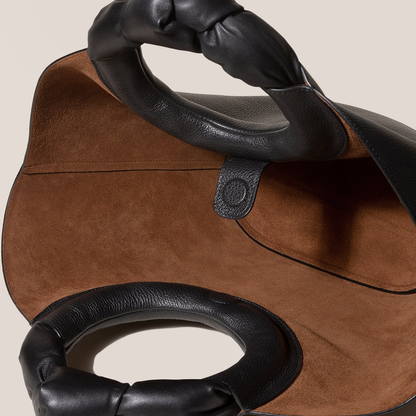 Solid Deep Black Pebbled Grain Wide Flared Carry Bag With Sculpted Knotted Circular Top Grip And Ruched Fabric Inner Storage Insert
