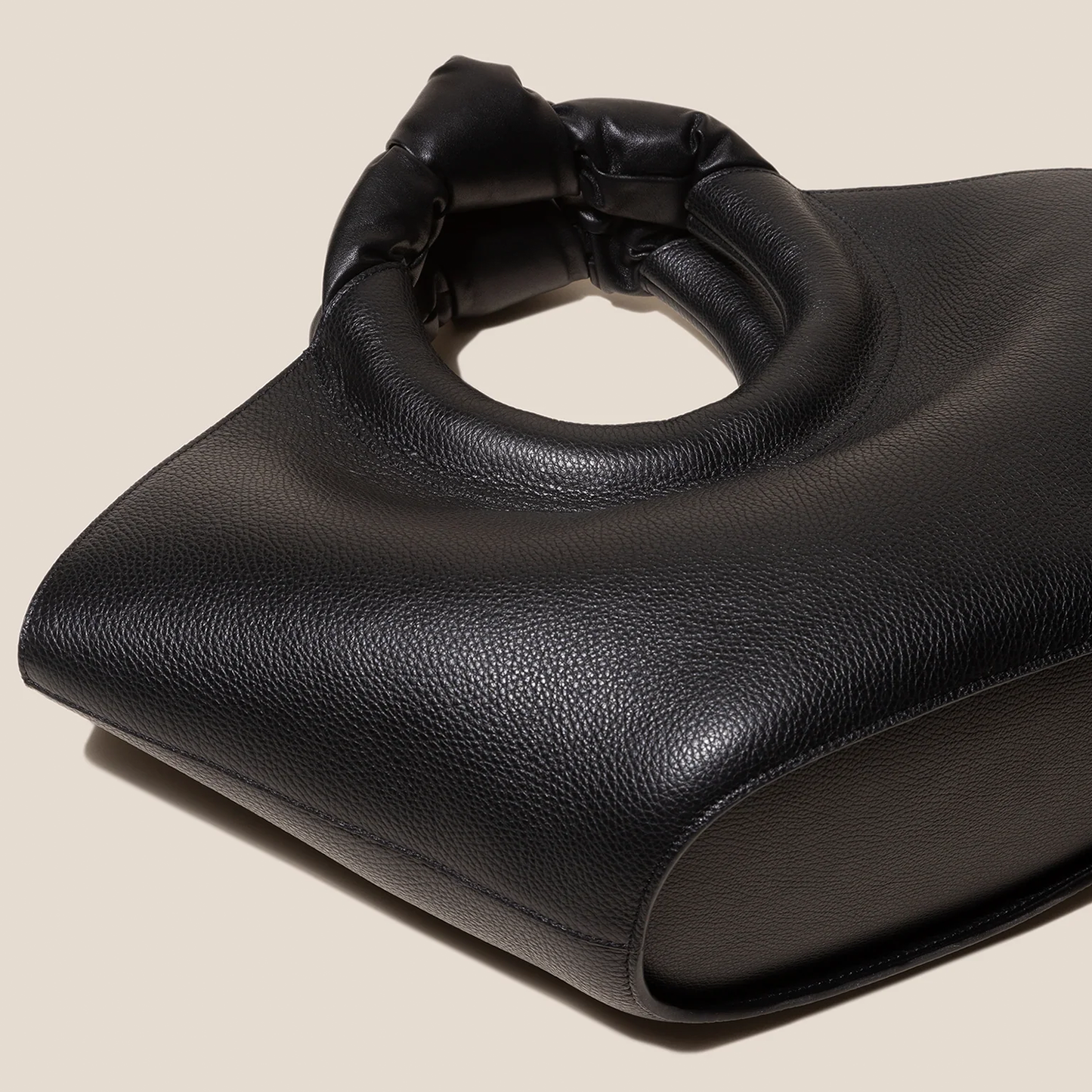 Solid Deep Black Pebbled Grain Wide Flared Carry Bag With Sculpted Knotted Circular Top Grip And Ruched Fabric Inner Storage Insert