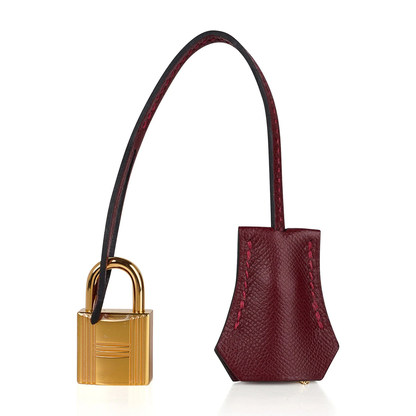 Deep Jewel Burgundy Fine Flat Grain Compact Box Structured Hand Tote With Radiant Golden Twist Lock Hardware And Matching Suspended Metal Padlock Charm